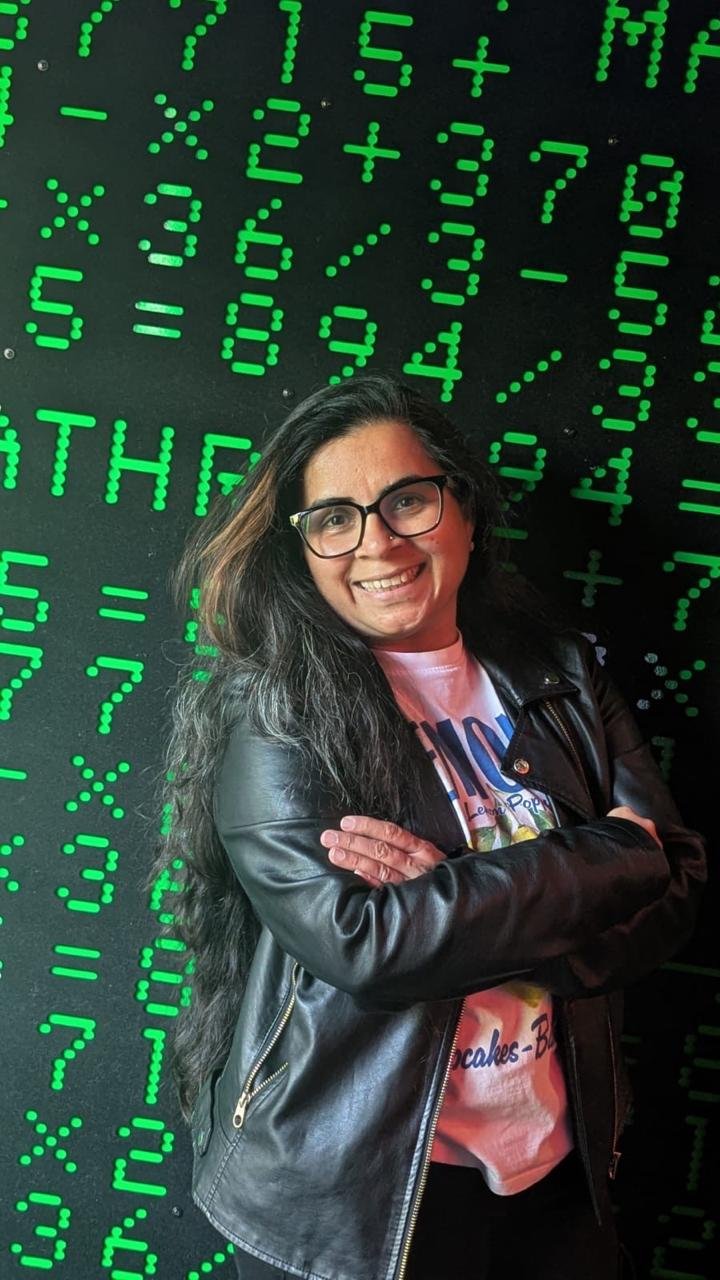 Sonal standing in front of a green digital display